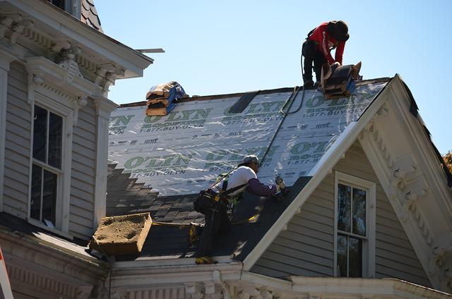 O'lyn Roofing crew performing roof replacement services.