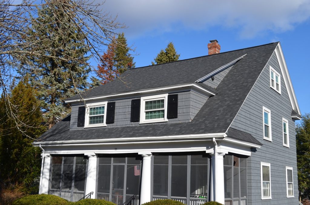 A grey sided two story home with new roofing material.