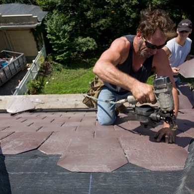 O'lyn Roofing crew on top of a home installing a slate roof.