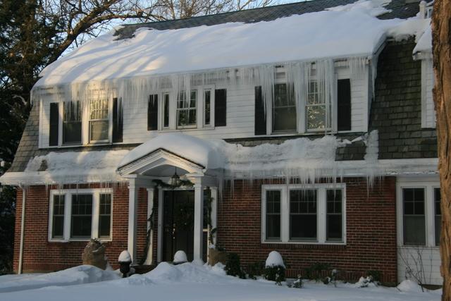 A two story home with icicles hanging off the roof.
