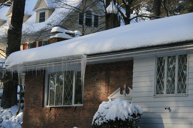 A snow covered home with a roof ice melt system installed by O'lyn Roofing.