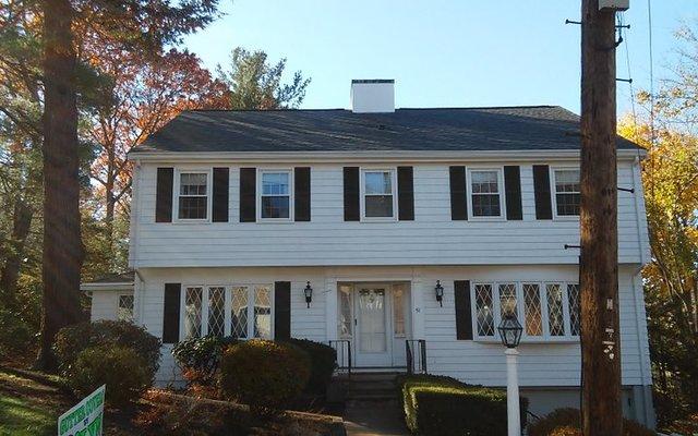 After picture of a home in Dedham with a new roof and gutter shutters.