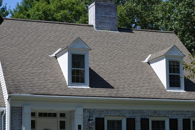 A home in Wellesley before O'lyn Roofing installed a new roof. The shingles are worn and dull.