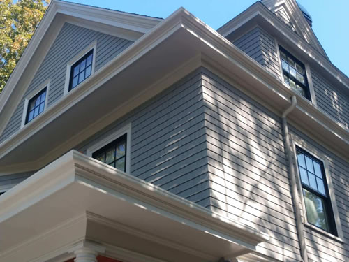 Fiberglass gutters installed on a gray two story home.