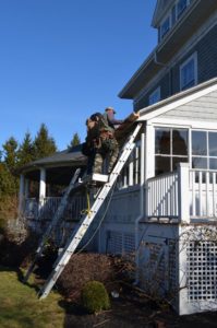 A crew installing new wood gutters on a home. 