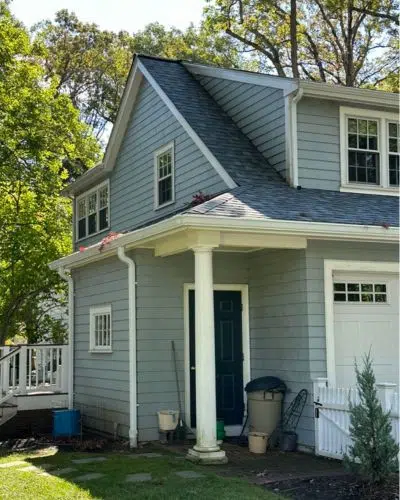 Blue house with clogged gutters