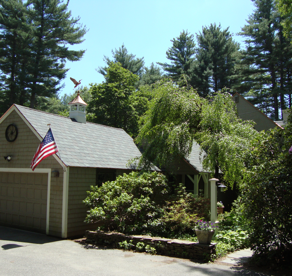 Gray asphalt shingle roof on residential garage with cupola and weather vane