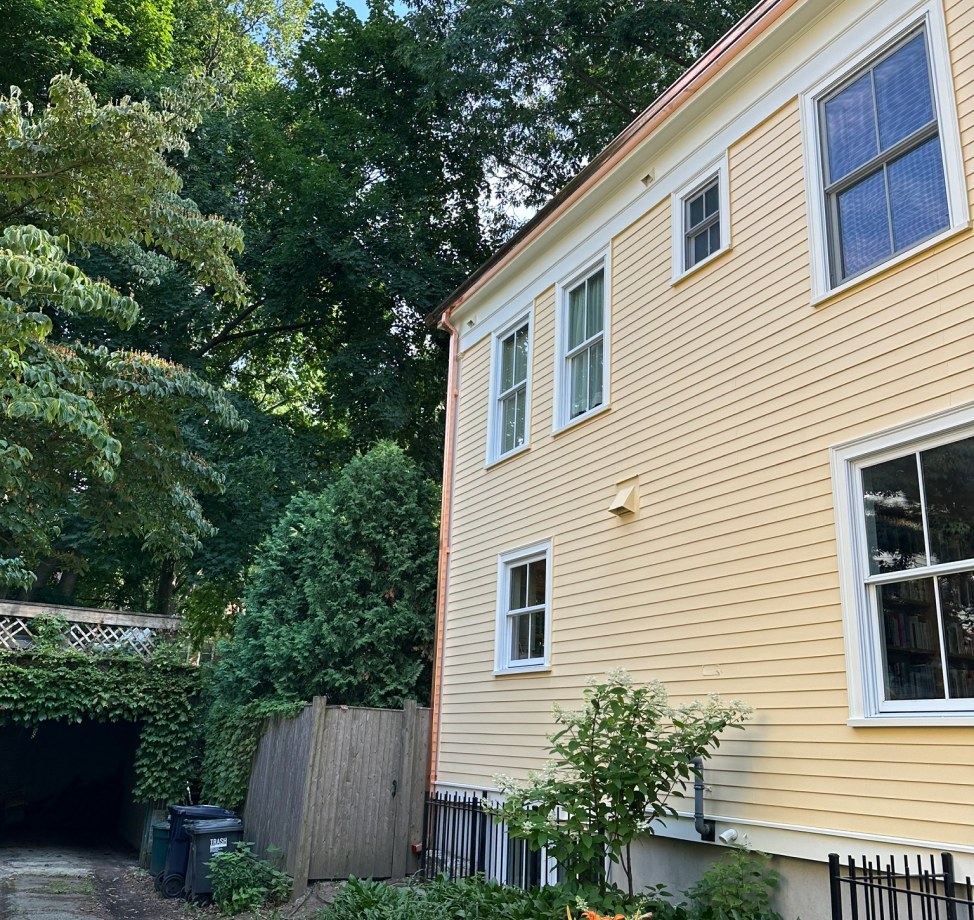 New copper gutters installed on yellow siding home
