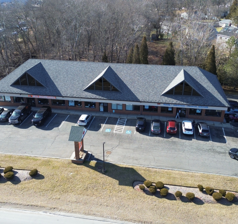 Commercial building with new roof and triangular dormer windows, viewed from above.