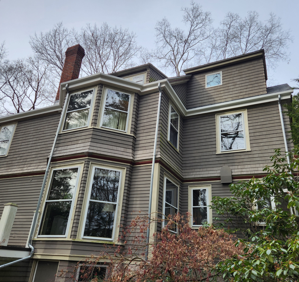 Three-story home with new dark asphalt shingle roof and brown siding