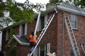  New gutters being installed on a two story home. 