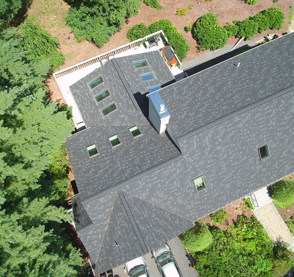 Aerial view of new asphalt shingle roof with skylights and chimney