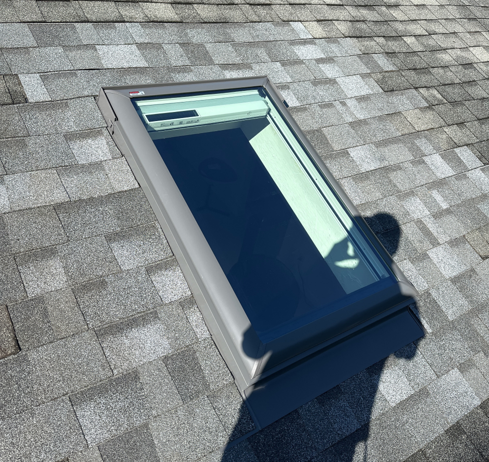New skylight installed on gray asphalt shingle roof