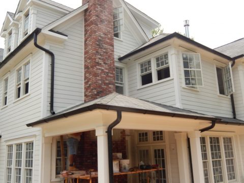 Large home with new gutters and downspouts being pictured. 